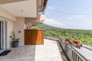 einen Balkon mit Holztür und Bergblick in der Unterkunft Veranda Guest House in Litochoro