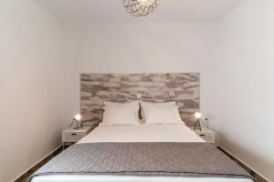 1 dormitorio con 1 cama con pared de ladrillo en Veranda Guest House, en Litóchoron