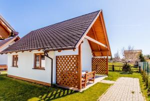 a small cottage with a pitched roof at Bursztynowy Zakątek Domki in Grzybowo