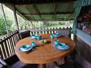 a wooden table with plates and glasses on it at Finca Sueno de Osa in Sirena