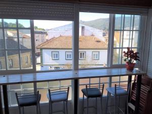 a bar with chairs and a view of a building at A Casa da Herba in Redondela