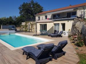 a swimming pool with lounge chairs and a house at Appt reposant entièrement équipé. in Toules