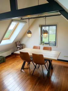 a dining room with a wooden table and chairs at Buitenplaats Langewijk in Zuidoostbeemster