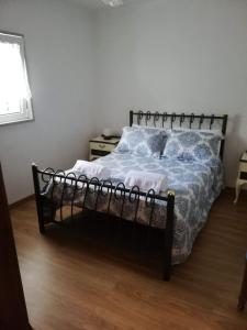 a bedroom with a bed with a blue comforter at As três irmãs in Bragança