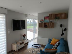 Toules的住宿－Appt reposant entièrement équipé.，客厅配有蓝色的沙发和电视