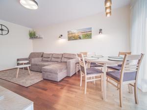 sala de estar con sofá, mesa y sillas en Moya Bay Apartament, en Gdansk