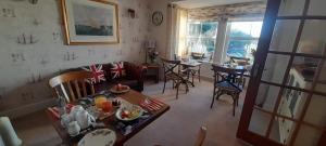a living room with a couch and a table and chairs at Little Orchard House in Salcombe