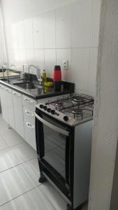 a kitchen with a stove and a sink at Cantinho Xodó in Capitólio