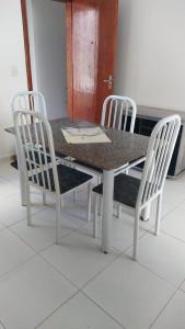 卡皮托利烏的住宿－Cantinho Xodó，餐桌、两把椅子、一张桌子和一张桌子