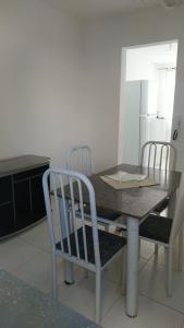 mesa de comedor con 4 sillas y cocina en Cantinho Xodó en Capitólio