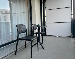 una mesa y 2 sillas sentadas en un balcón en Studio Stevie Nicks I Parking Spot I Workplace I 24in Screen I Kitchen I PS4, en Offenbach