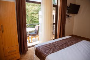 a bedroom with a bed and a balcony with a table at Ndaru Luxury suites in Kigali