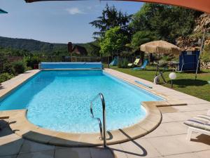 ein Schwimmbad in der Mitte eines Gartens in der Unterkunft Val Paradis in Espagnac-Sainte-Eulalie