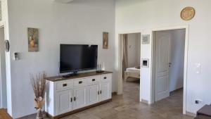 a living room with a flat screen tv on a cabinet at Casa Levante in Chiclana de la Frontera