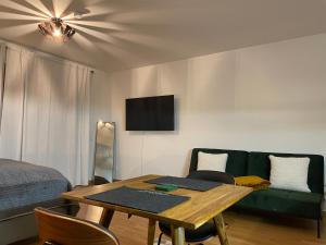 sala de estar con mesa y sofá en Studio Stevie Nicks I Parking Spot I Workplace I 24in Screen I Kitchen I PS4, en Offenbach