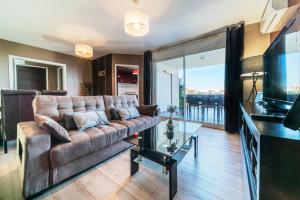 un soggiorno con un divano e una grande finestra di T2 classé 4 étoiles avec jardin, piscine, vue mer à Saint-Gilles-les-Bains a Saint-Gilles-les Bains