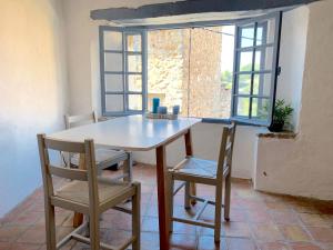 a table and chairs in a room with a window at Chez Franck, charmant dorpshuis met unieke sfeer in Tourrettes-sur-Loup +12 photos