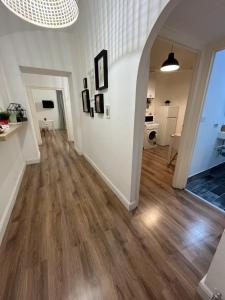 ein leeres Wohnzimmer mit Holzböden und einem Torbogen in der Unterkunft MiRhome Apartment in Rom
