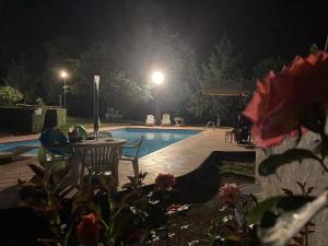 uma piscina à noite com mesa e cadeiras em Masseria Le Zavattole em Sasso