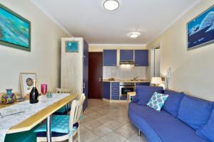 a living room with a blue couch and a table at InBlue in Savudrija