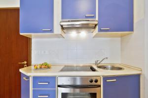 a kitchen with blue cabinets and a sink at InBlue in Savudrija +3 photos