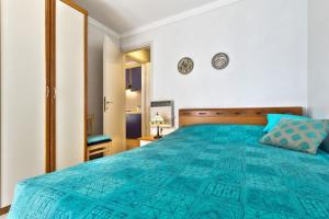 Schlafzimmer mit einem großen Bett mit blauer Tagesdecke in der Unterkunft InBlue in Savudrija