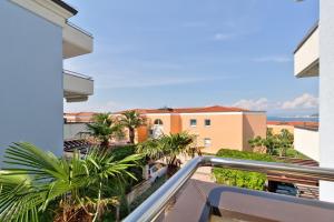 a balcony with a view of palm trees and buildings at InBlue in Savudrija