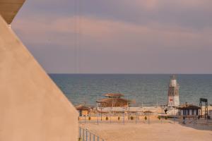 a lighthouse on a beach with the ocean at WAVE 4 Apartments Mamaia Nord in Năvodari