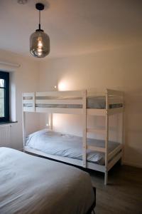 a bedroom with two bunk beds and a lamp at Vakantiewoning Spoor 23 in Borgloon