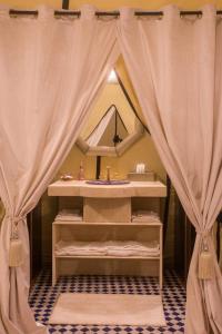 a bathroom with a sink and a mirror at Luxury Desert Camp Amanar in Merzouga
