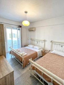 1 dormitorio con 2 camas y ventana en George Studios en Naxos