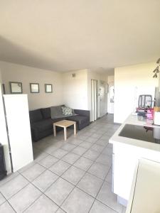 cocina y sala de estar con sofá en Appartement Vue Mer 212, en Canet-en-Roussillon