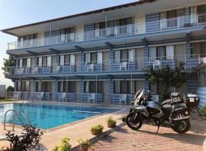 a motorcycle parked in front of a hotel with a swimming pool at Hotel Goreme Sakura in Pamukkale