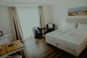 a bedroom with a white bed and a window at Pension Frisia in Norddeich