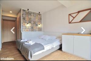 1 dormitorio con 1 cama con toallas en Na Fali Restaurant&Apartaments, en Pobierowo
