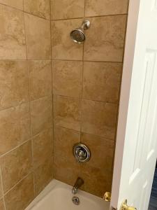 a bathroom with a shower with a bath tub at Hill Top Motel in Wrightstown