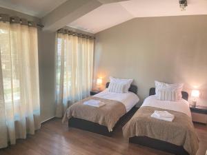 a bedroom with two beds and a window at Къща за гости Мегдана in Sopot