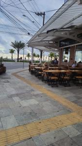 En restaurant eller et andet spisested på Boqueirão Praia Mar - 2 dormits - Espaçoso e ideal para famílias - WI FI - 250m da praia - Estacionamento Gratuito até 8 hóspedes - na avenida do comércio principal de Praia Grande