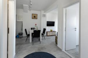 a living room with a table and chairs and a television at Gustav - Sea view apartment with balcony in Cavtat