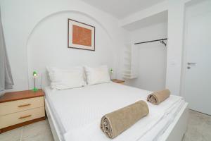 a bedroom with a white bed with towels on it at Gustav - Sea view apartment with balcony in Cavtat