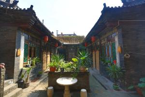 einen Innenhof eines Gebäudes mit Topfpflanzen in der Unterkunft Pingyao Laochenggen Inn in Pingyao