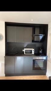 eine Küche mit Herd und Mikrowelle in der Unterkunft Charmante maison de ville in Périgueux