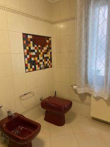 La salle de bains est pourvue de toilettes brunes et d'un lavabo. dans l'établissement Casa di Angela, à Chioggia