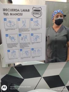 Una mujer con una máscara parada junto a una señal en Hotel La Aldea del Oriente en Marinilla
