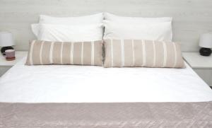 - un lit blanc avec 2 oreillers dans l'établissement Lightful Attic at Regina Apartments, à Alikanas