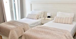 - une chambre avec 2 lits et une fenêtre dans l'établissement Lightful Attic at Regina Apartments, à Alikanas