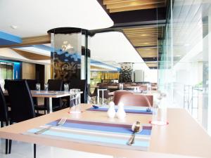 a dining room with tables and chairs in a restaurant at Grand Tower Inn Sathorn Hotel in Bangkok