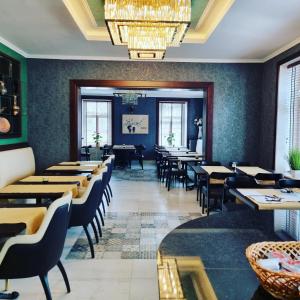 a dining room with tables and chairs and a chandelier at A&F Hotel Chemnitz in Chemnitz