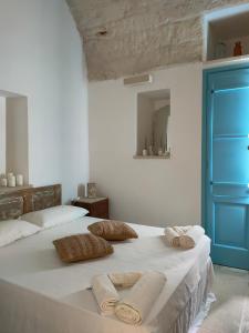 una camera da letto con un grande letto bianco con asciugamani di Ca'SaLentu - La Corte dei Colori a Spongano