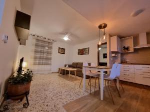 a kitchen and living room with a table and a couch at APARTAMENTOS EL ALCAZAR VIEJO (SAN BASILIO) in Córdoba